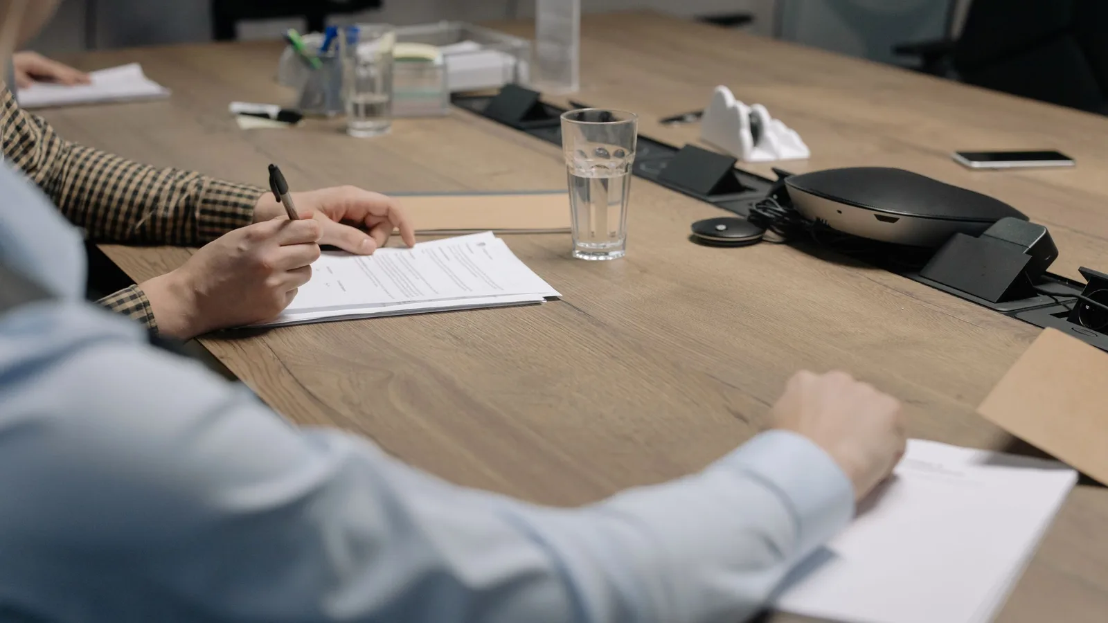 Riunione di lavoro con documenti contrattuali su un tavolo