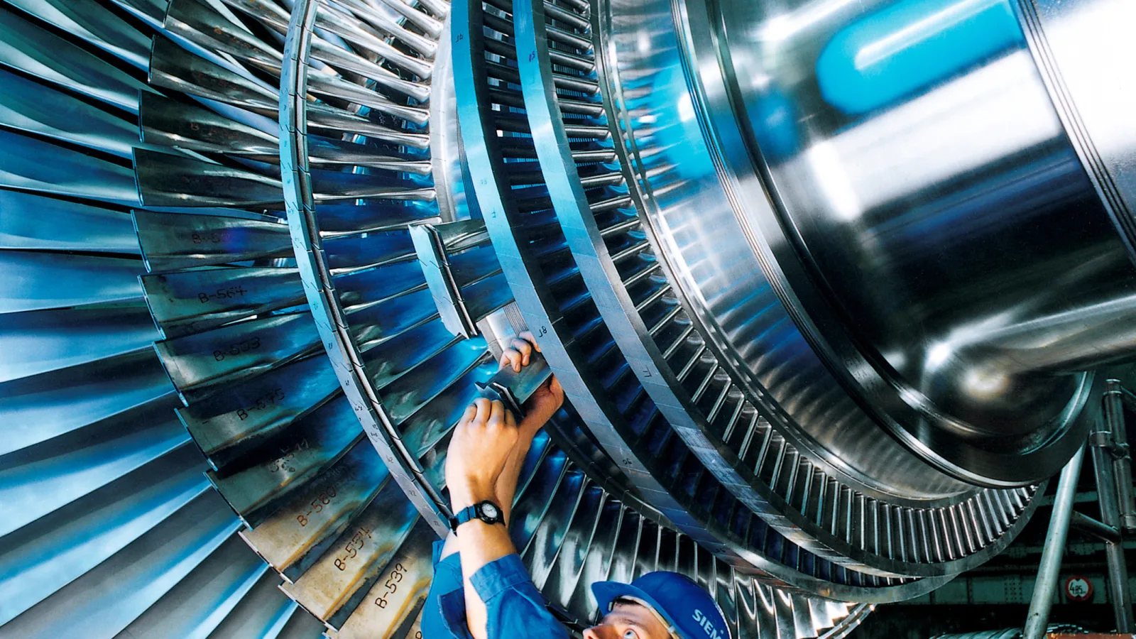 Operaio al lavoro su un rotore industriale in uno stabilimento manifatturiero