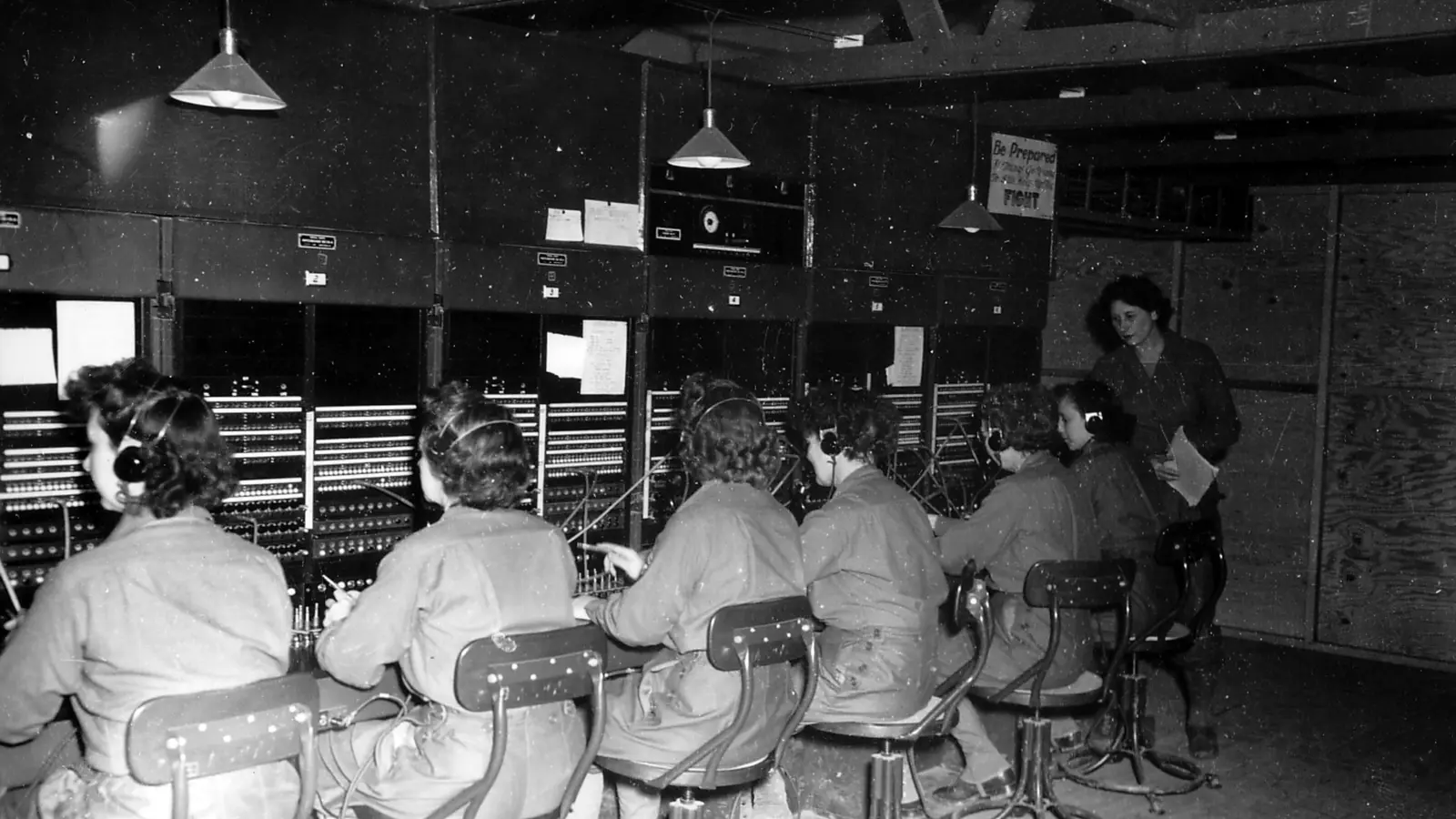 Operatrici al lavoro davanti a un centralino telefonico storico