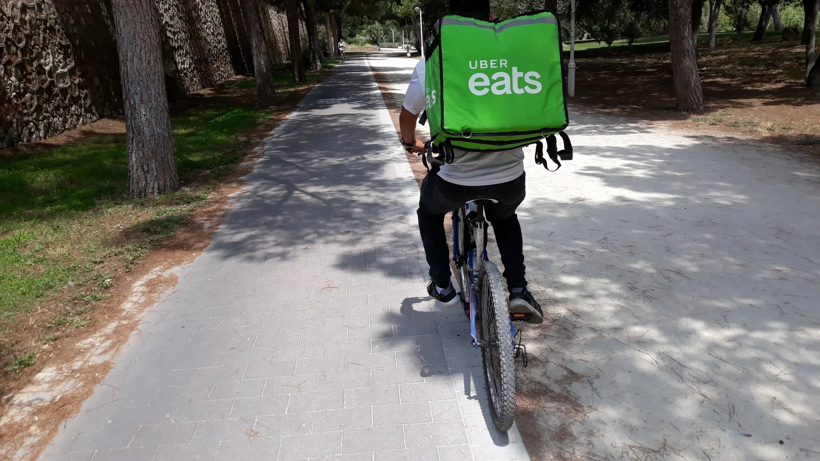 Ciclisti per consegne su una pista ciclabile urbana, esempio di lavoro organizzato tramite piattaforme digitali