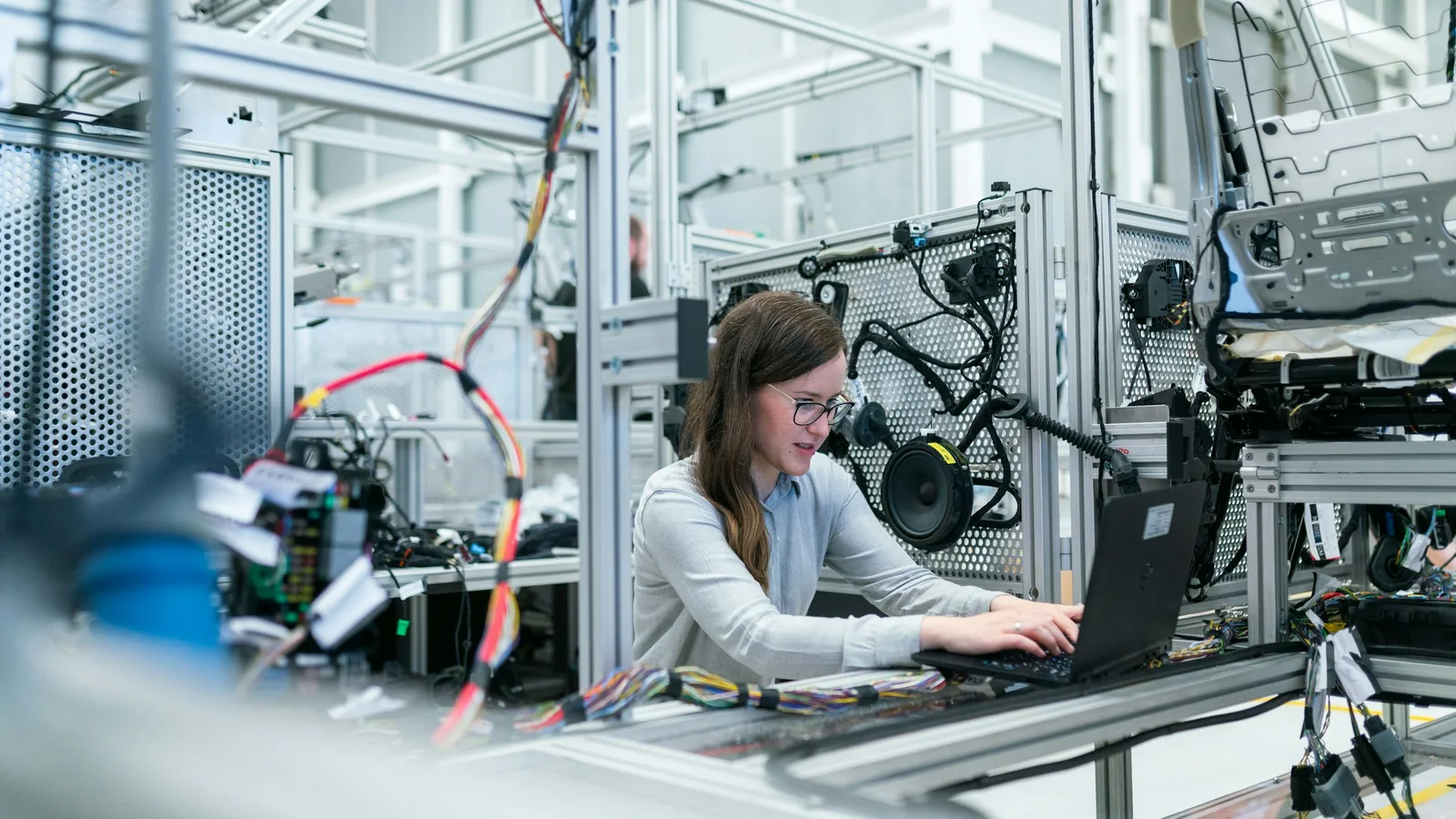 Ingegnera al lavoro con un computer portatile in un laboratorio manifatturiero