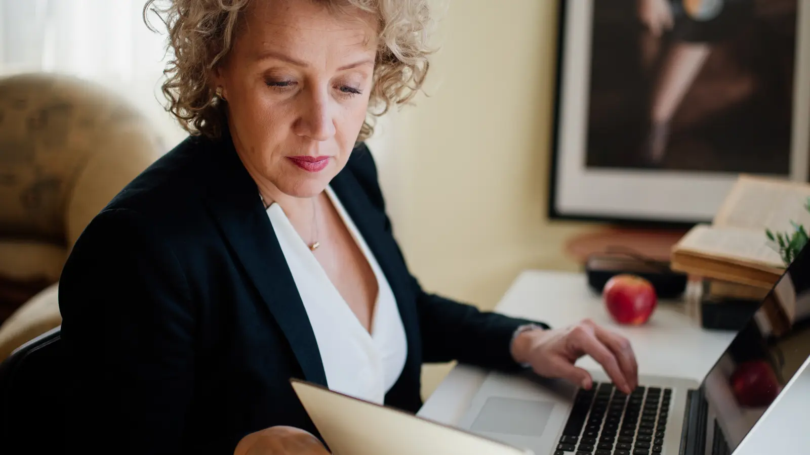 Lavoratrice in ufficio consulta documenti al computer, immagine illustrativa della scelta sul TFR