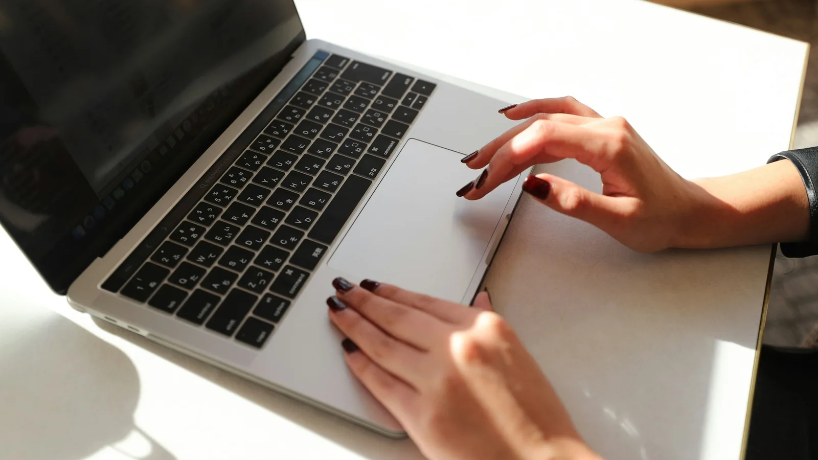 Mani su un computer portatile durante una pratica di lavoro online