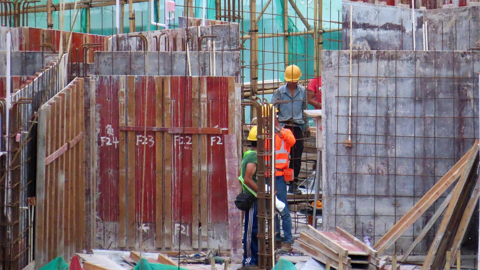 Lavoratori con caschi e giubbotti ad alta visibilità in un cantiere all’aperto