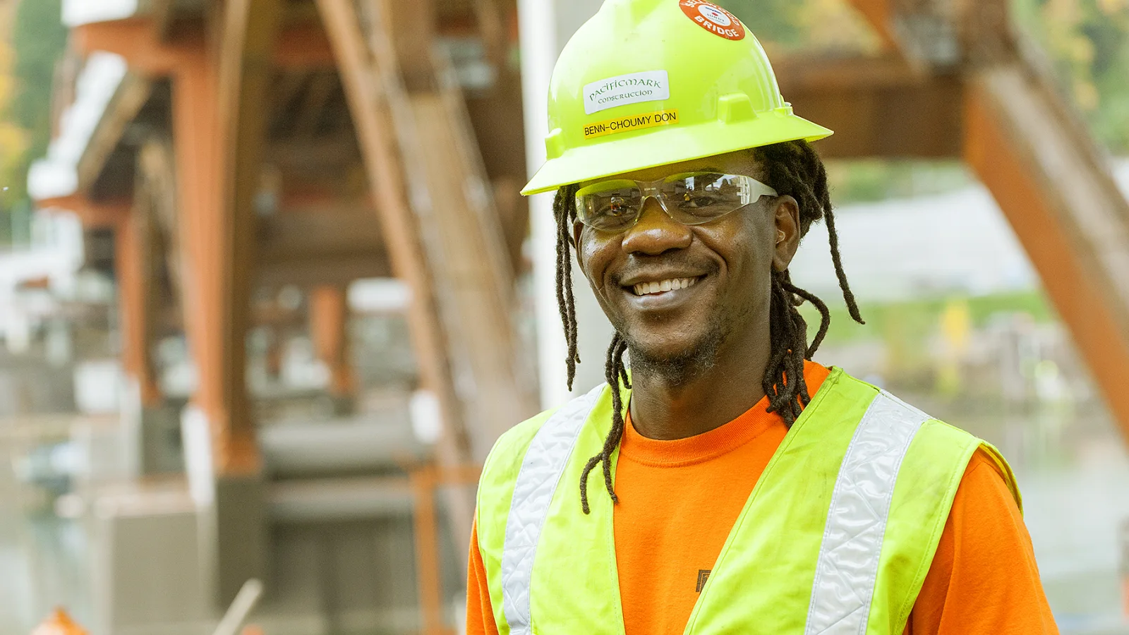 Apprendista carpentiere con casco e gilet riflettente in un cantiere